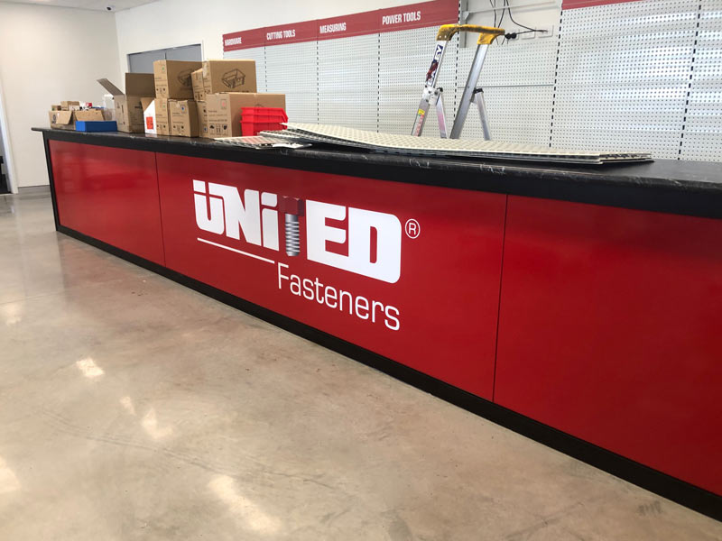 bright red front counter sign with logo for united fastners